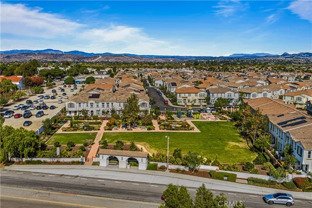 an aerial view of residential houses with outdoor space and ocean view