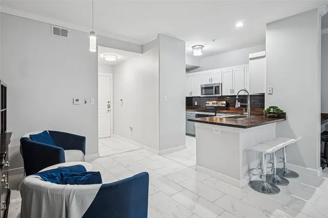 a kitchen with stainless steel appliances kitchen island granite countertop a refrigerator and a stove top oven