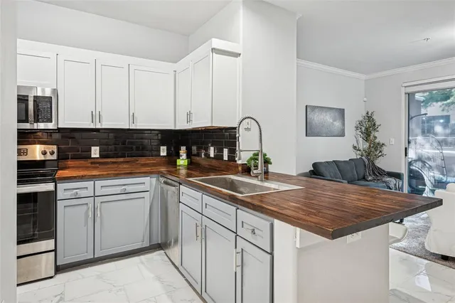a kitchen with granite countertop a sink and white cabinets