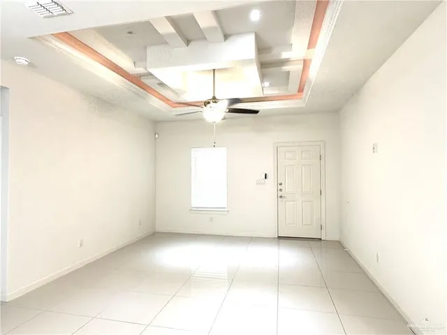 a view of a room with a ceiling fan and window