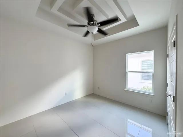 en empty room with windows and ceiling fan