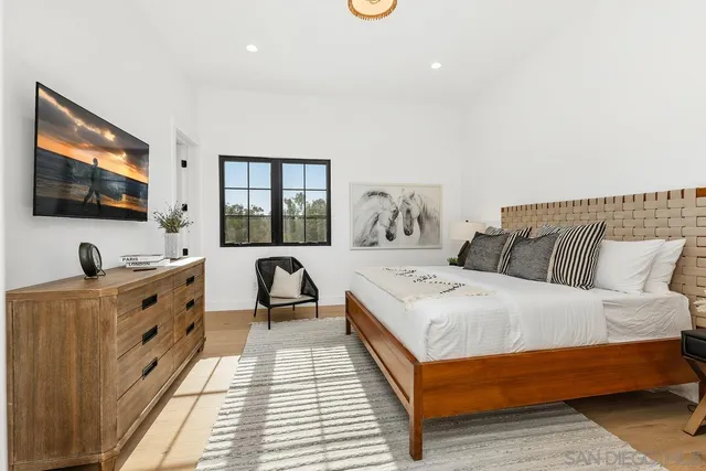 a living room with furniture a window and a flat screen tv