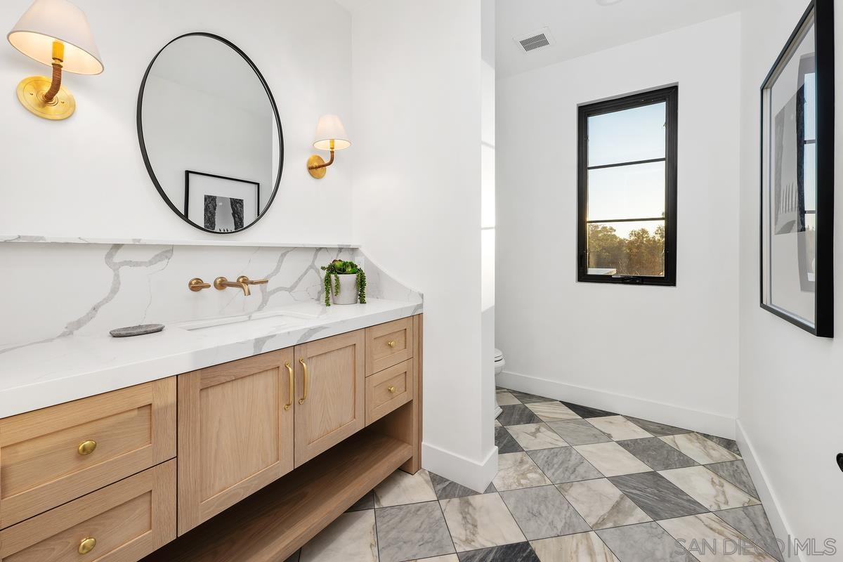 6691 Camino Saucito Rancho Santa Fe, CA 92067 - Photo 37 of 55 a bathroom with a sink mirror and vanity