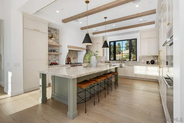 a dining hall with stainless steel appliances granite countertop a sink and a refrigerator