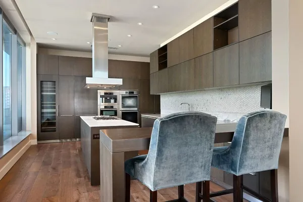 a kitchen with a table chairs refrigerator and cabinets