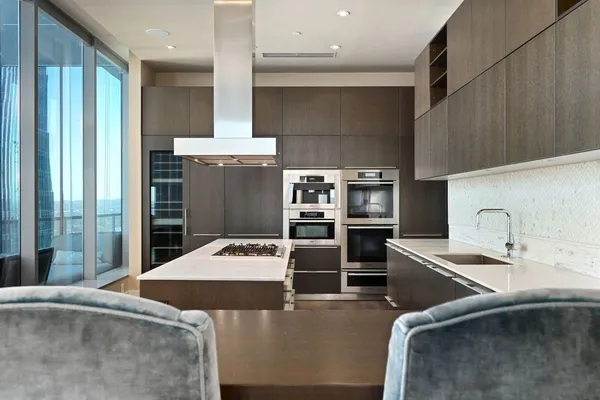 a kitchen with stainless steel appliances kitchen island granite countertop a sink stove and refrigerator