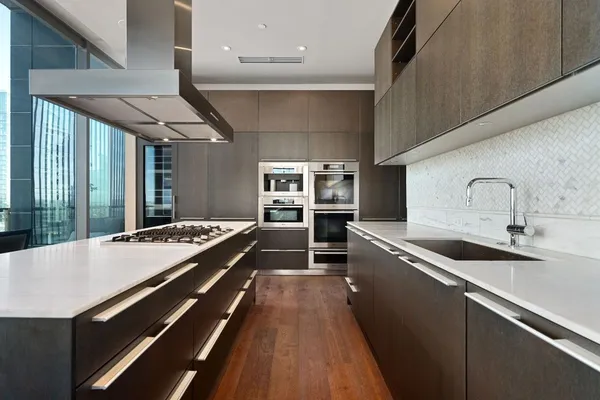 a large kitchen with kitchen island a sink stainless steel appliances and a large window