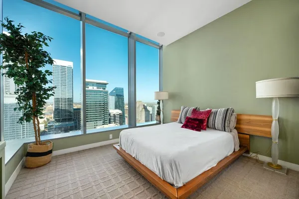 a bedroom with a bed and a potted plant