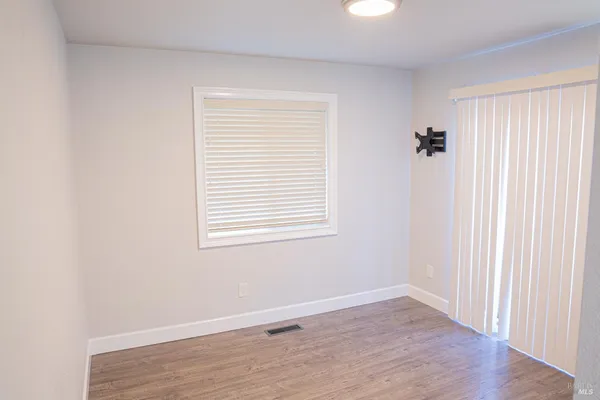 an empty room with wooden floor and a window
