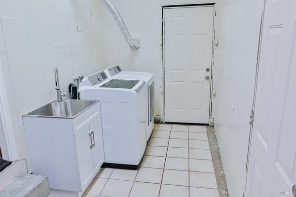 a utility room with cabinets washer and dryer