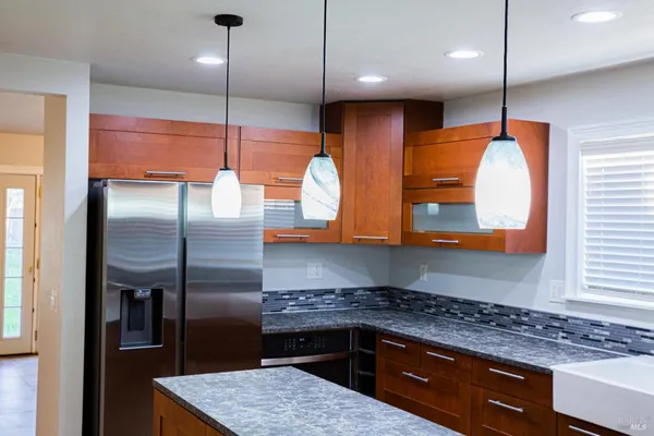 a kitchen with stainless steel appliances granite countertop a sink a stove and a refrigerator