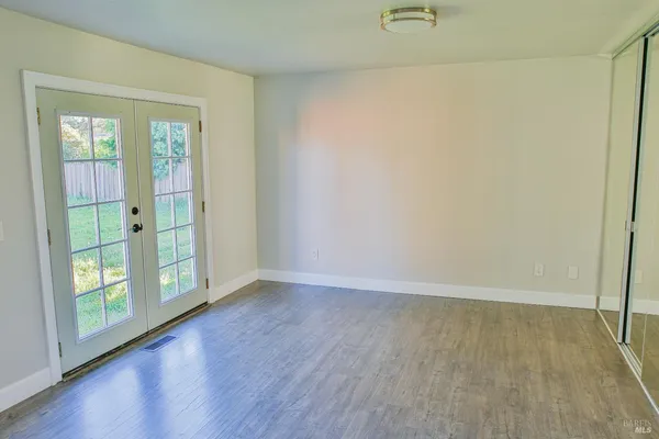 an empty room with wooden floor and windows