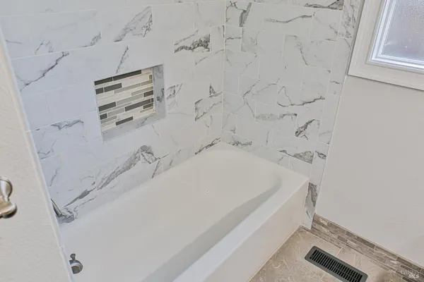 a bathroom with a bathtub and shower
