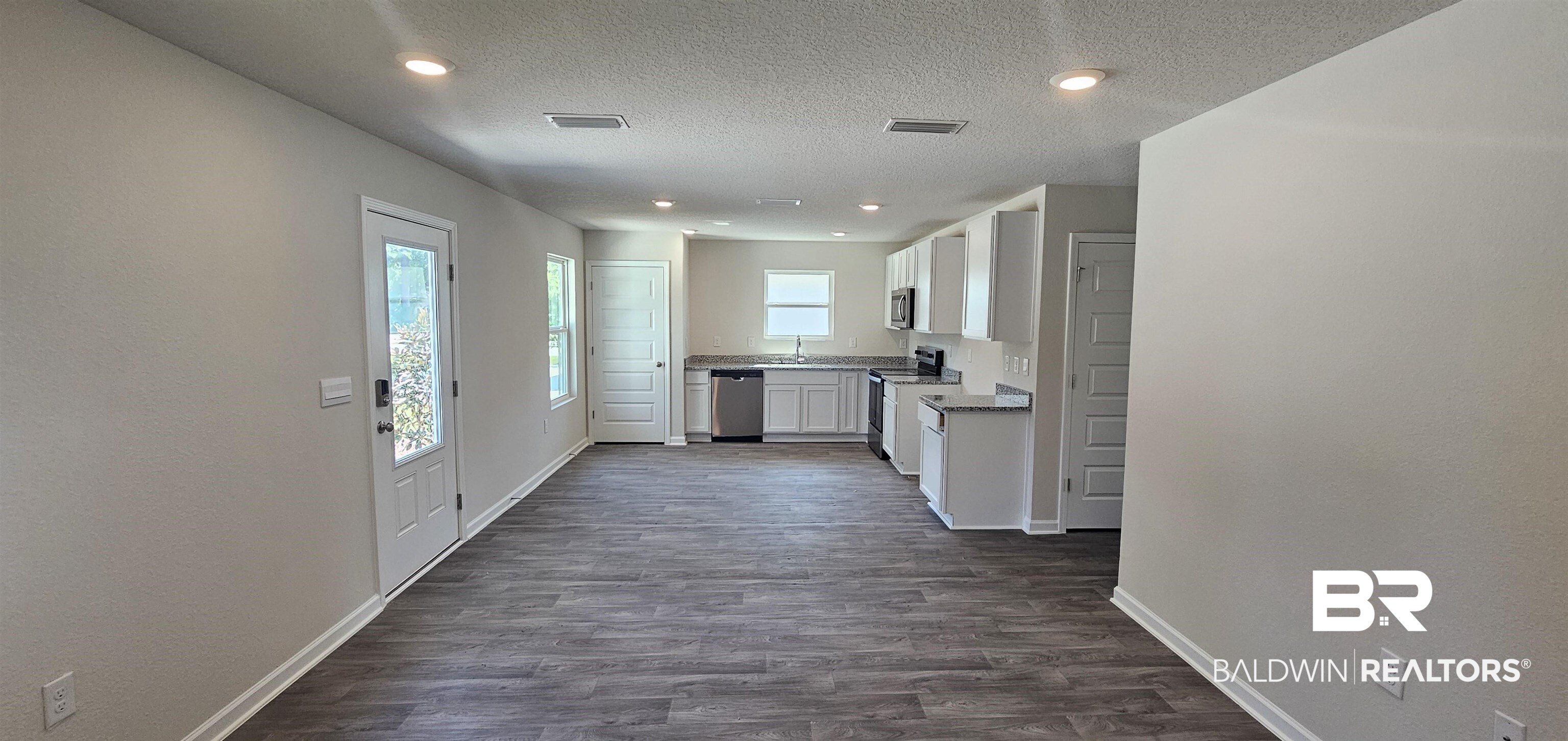 1024 South Bay Street Foley, AL 36535 - Photo 3 of 28 Kitchen featuring a textured ceiling, appliances with stainless steel finishes, dark hardwood / wood-style flooring, and white cabinetry