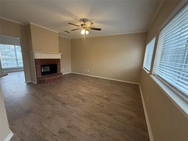 wooden floor fireplace and windows in an empty room