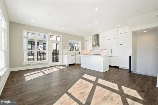 a view of a kitchen with wooden floor and windows