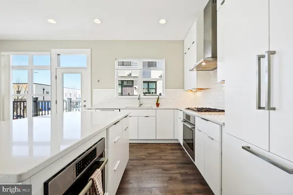 a large kitchen with stainless steel appliances granite countertop a lot of counter space and wooden floors