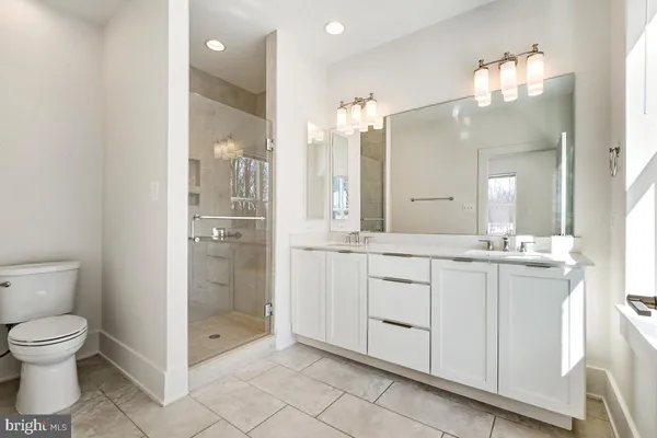 a bathroom with a granite countertop sink mirror and toilet