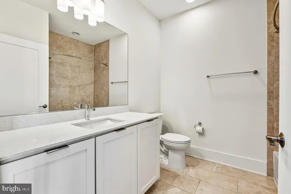 a bathroom with a sink a toilet a mirror and shower