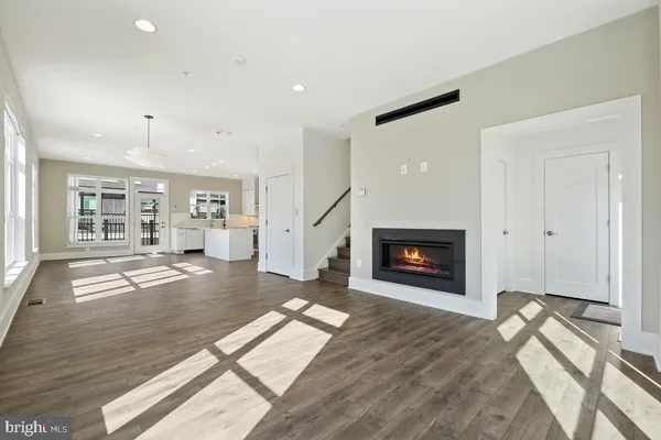 a view of a livingroom with wooden floor and a fireplace