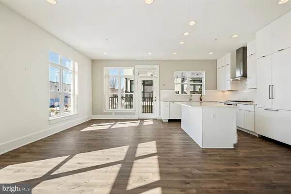 a view of a kitchen with refrigerator and wooden floor