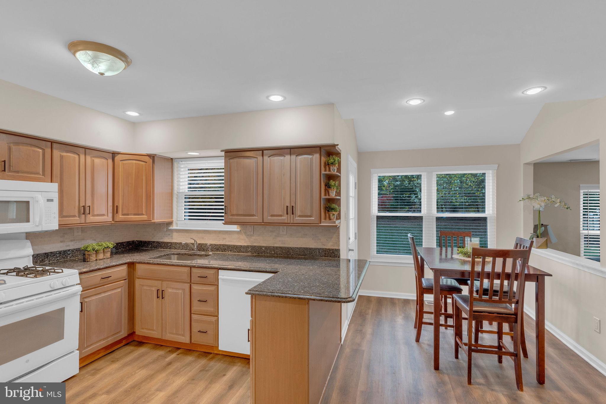 2158 Green Ridge Drive Warrington, PA 18976 - Photo 13 of 34 a kitchen with a table chairs wooden floors and white stainless steel appliances