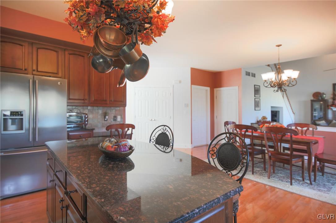 580 Rockbridge Road Nazareth, PA 18064 - Photo 12 of 30 a kitchen with stainless steel appliances granite countertop a stove a refrigerator a sink a dining table and chairs with wooden floor