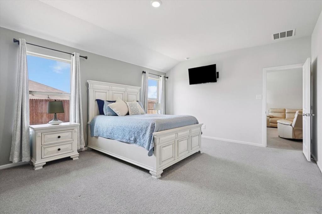 16733 Portage Street Justin, TX 76247 - Photo 13 of 39 a bedroom with a bed and a flat tv screen on dresser