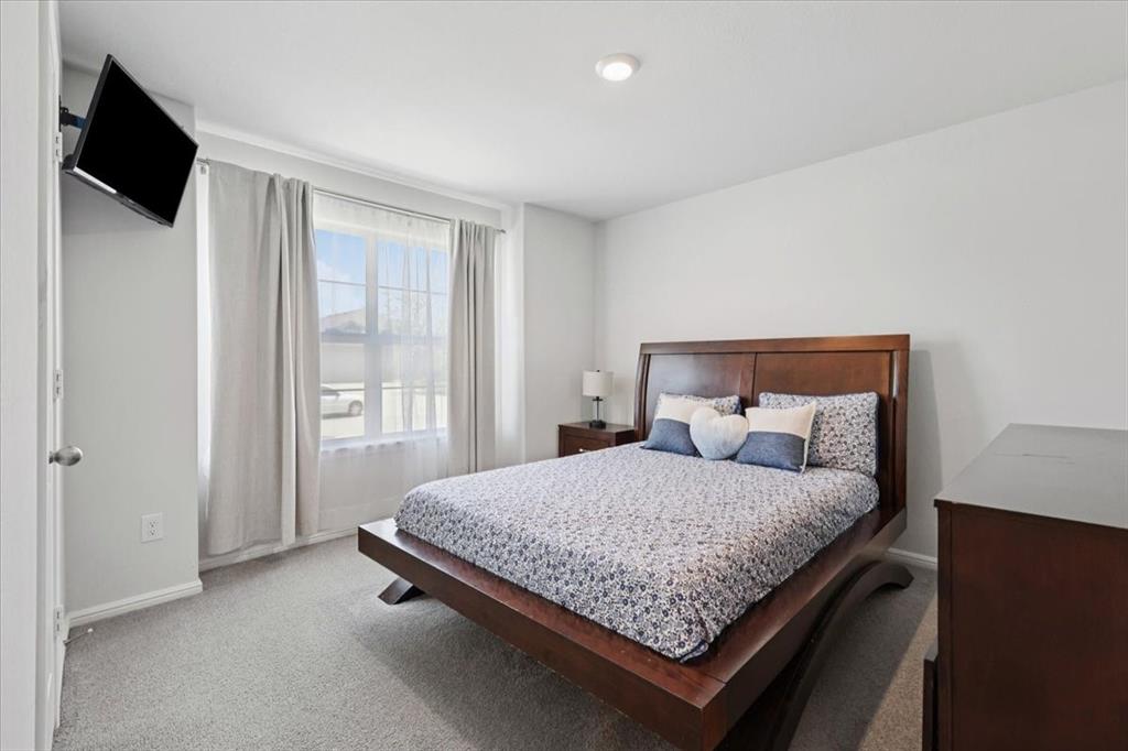 16733 Portage Street Justin, TX 76247 - Photo 20 of 39 a bedroom with a bed and flat screen tv