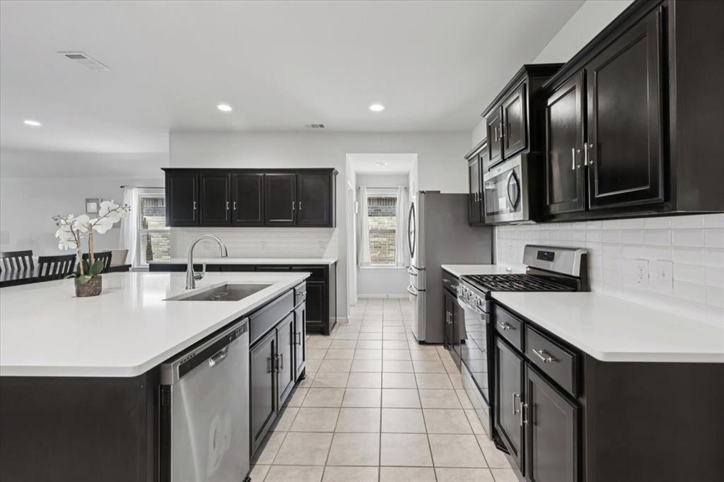 16733 Portage Street Justin, TX 76247 - Photo 27 of 39 a kitchen with stainless steel appliances a stove sink microwave and cabinets