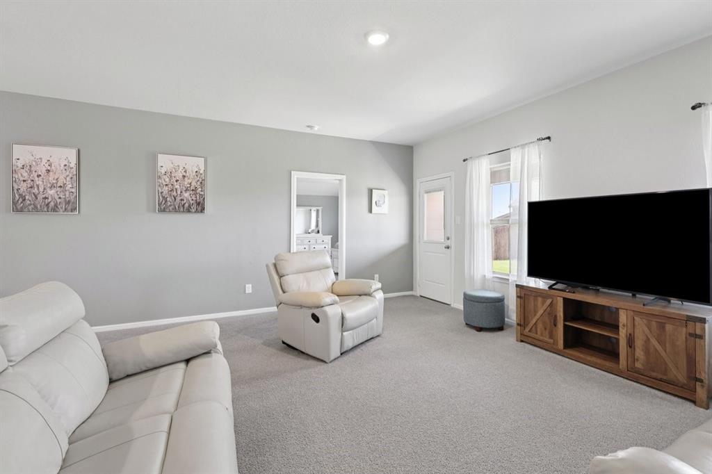 16733 Portage Street Justin, TX 76247 - Photo 34 of 39 a living room with furniture and a flat screen tv