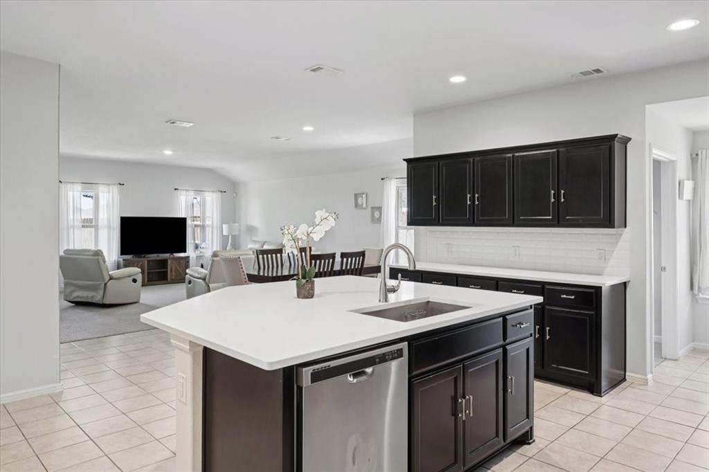 16733 Portage Street Justin, TX 76247 - Photo 5 of 39 a kitchen with a sink and a stove top oven with wooden cabinets