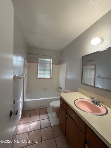 a bathroom with a sink a toilet a mirror and shower