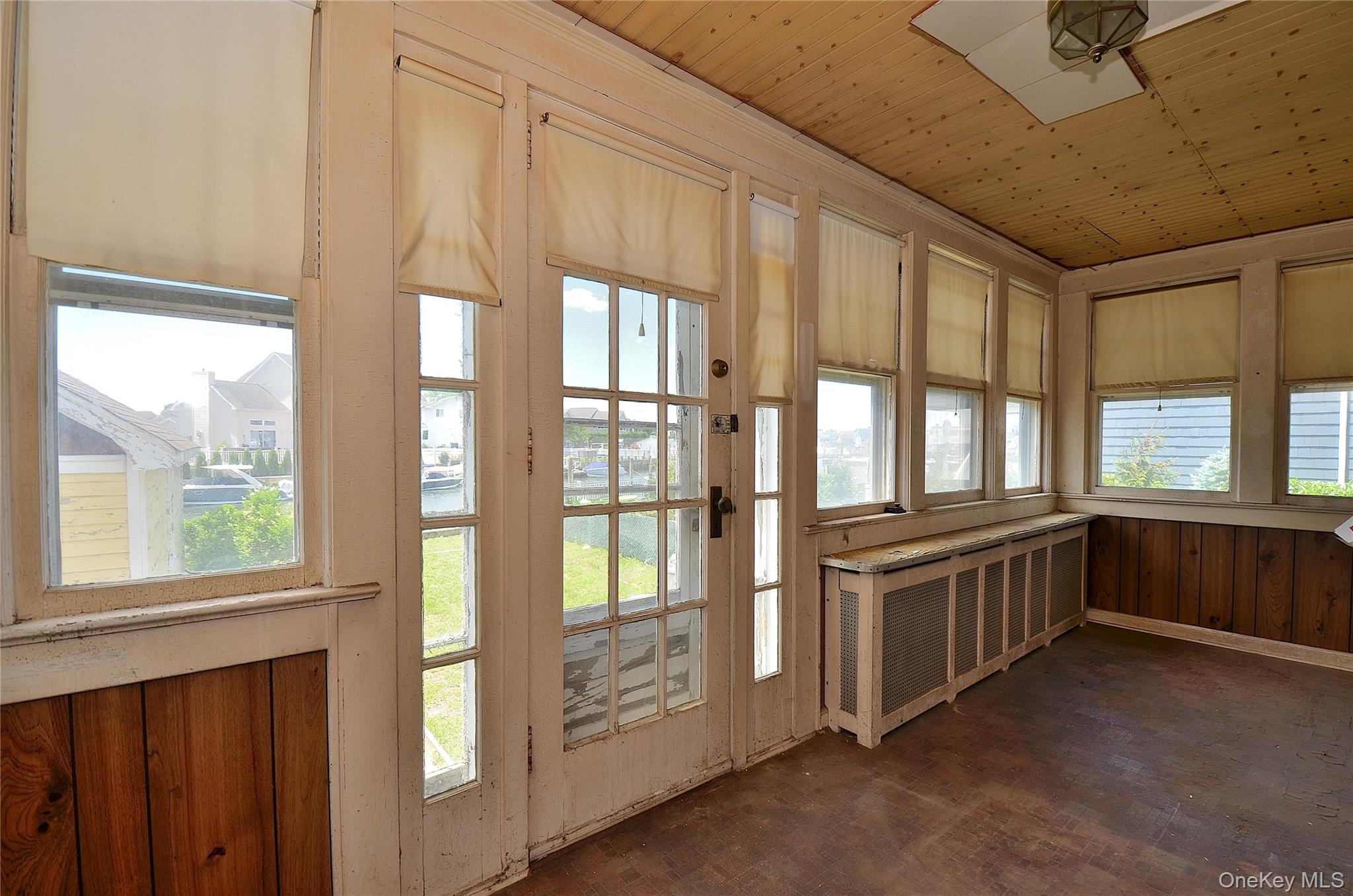 2586 Riverside Drive Wantagh, NY 11793 - Photo 26 of 28 Sunroom featuring wood-paneled walls, wood-finish flooring, and a wood-plank ceiling
