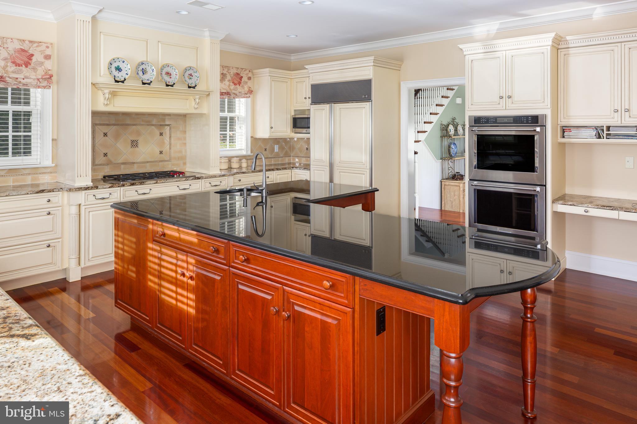 152 Grubb Road Malvern, PA 19355 - Photo 26 of 74 a kitchen with stainless steel appliances granite countertop a refrigerator a stove and white cabinets with wooden floor