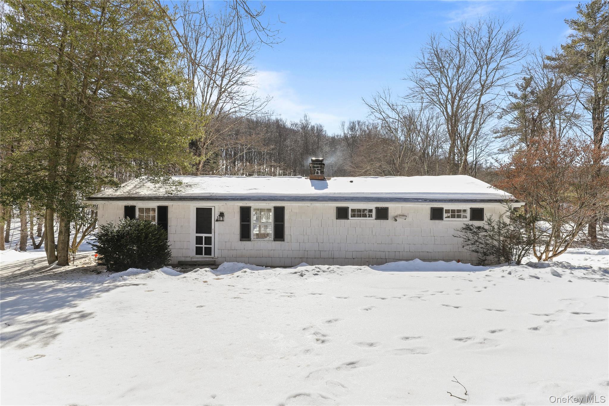 a front view of house with yard covered in snow