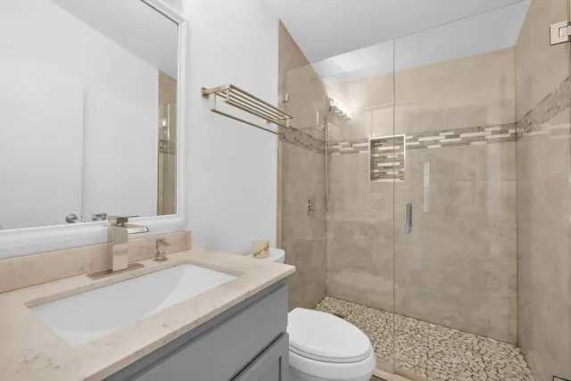 a bathroom with a sink a toilet and shower