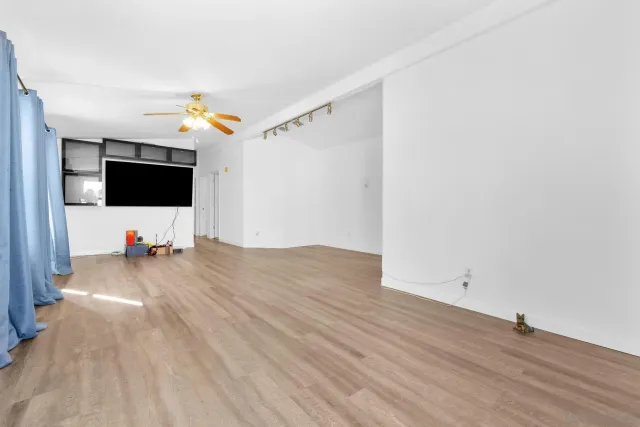 a view of a livingroom with wooden floor and flat screen tv