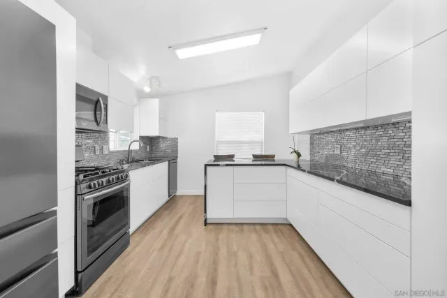 a kitchen with granite countertop a stove top oven sink and cabinets