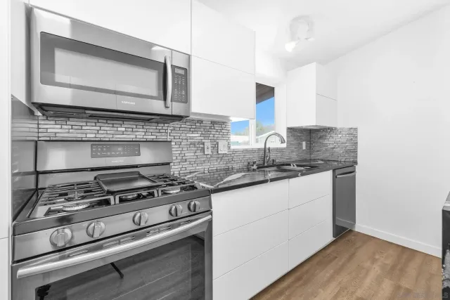 a kitchen with stainless steel appliances granite countertop a stove and a microwave