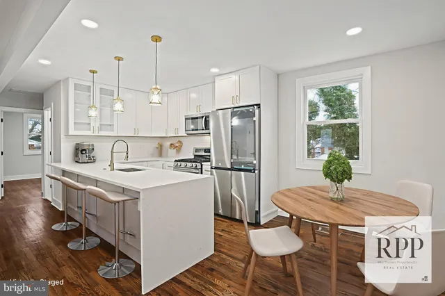 a kitchen with a refrigerator a stove a sink and a dining table