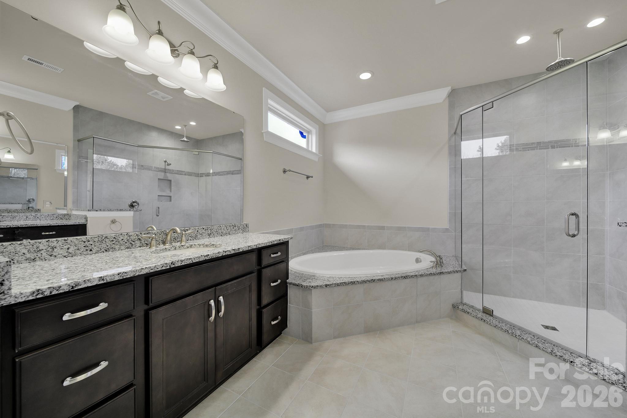 6507 Calvert Commons Drive Huntersville, NC 28078 - Photo 20 of 47 a bathroom with a granite countertop sink a toilet a mirror and shower