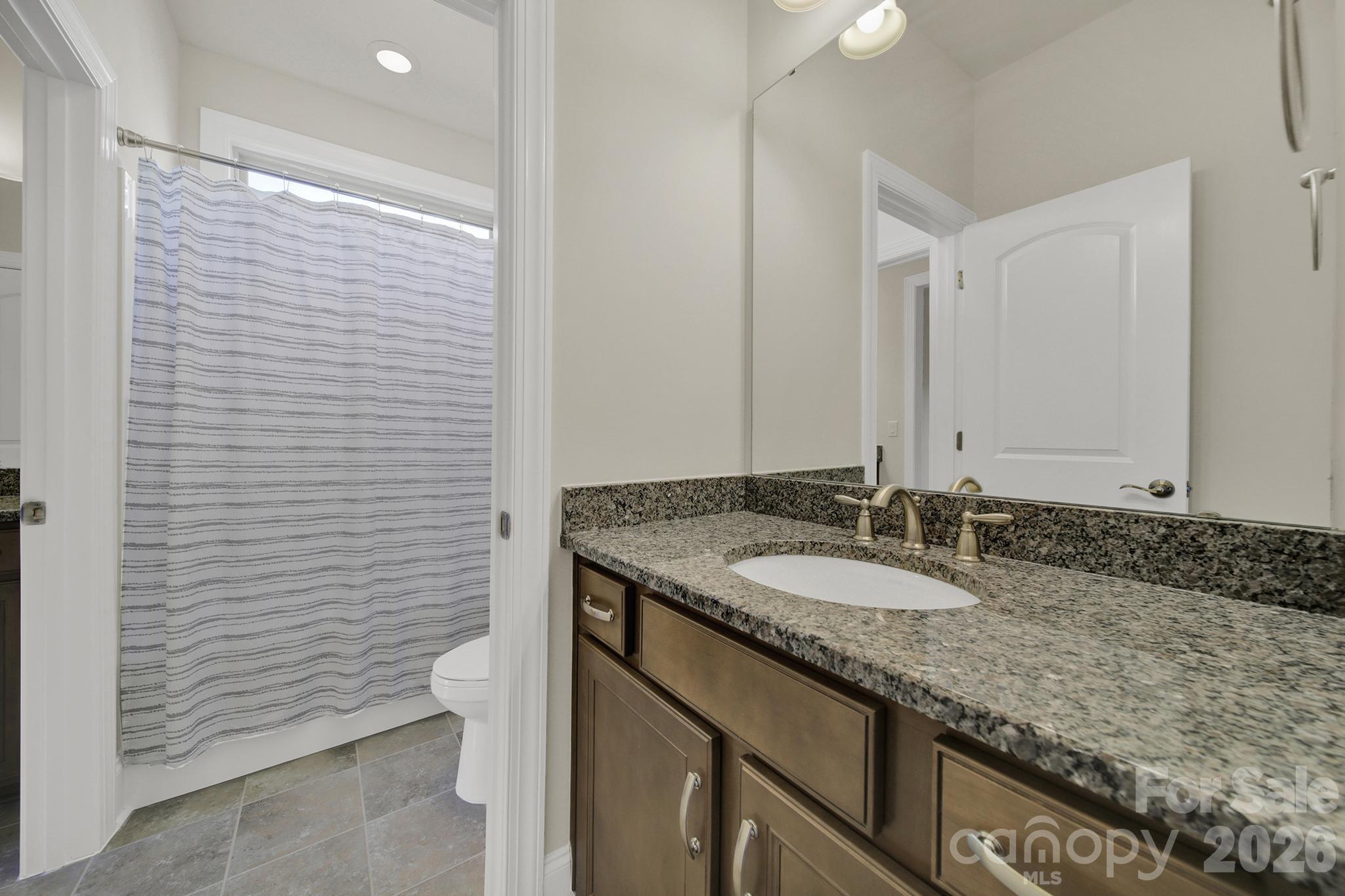 6507 Calvert Commons Drive Huntersville, NC 28078 - Photo 27 of 47 a bathroom with a granite countertop sink and a mirror