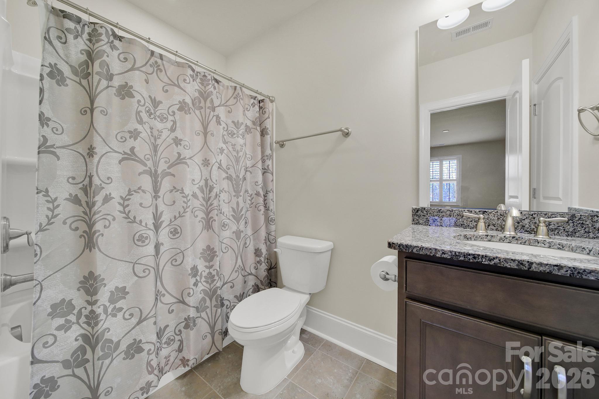 6507 Calvert Commons Drive Huntersville, NC 28078 - Photo 38 of 47 a bathroom with a granite countertop sink and a toilet