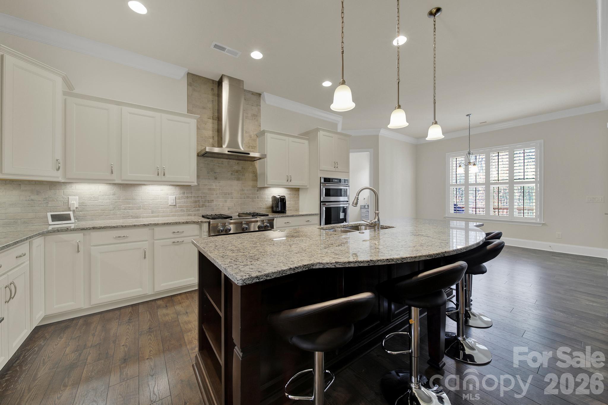 6507 Calvert Commons Drive Huntersville, NC 28078 - Photo 5 of 47 a kitchen with a table chairs sink and cabinets