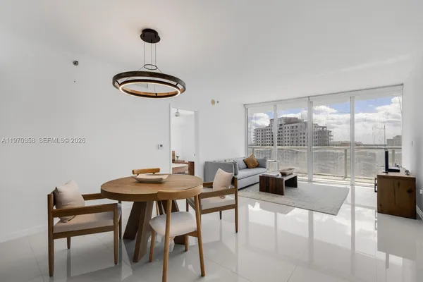 a dining room with furniture and a floor to ceiling window