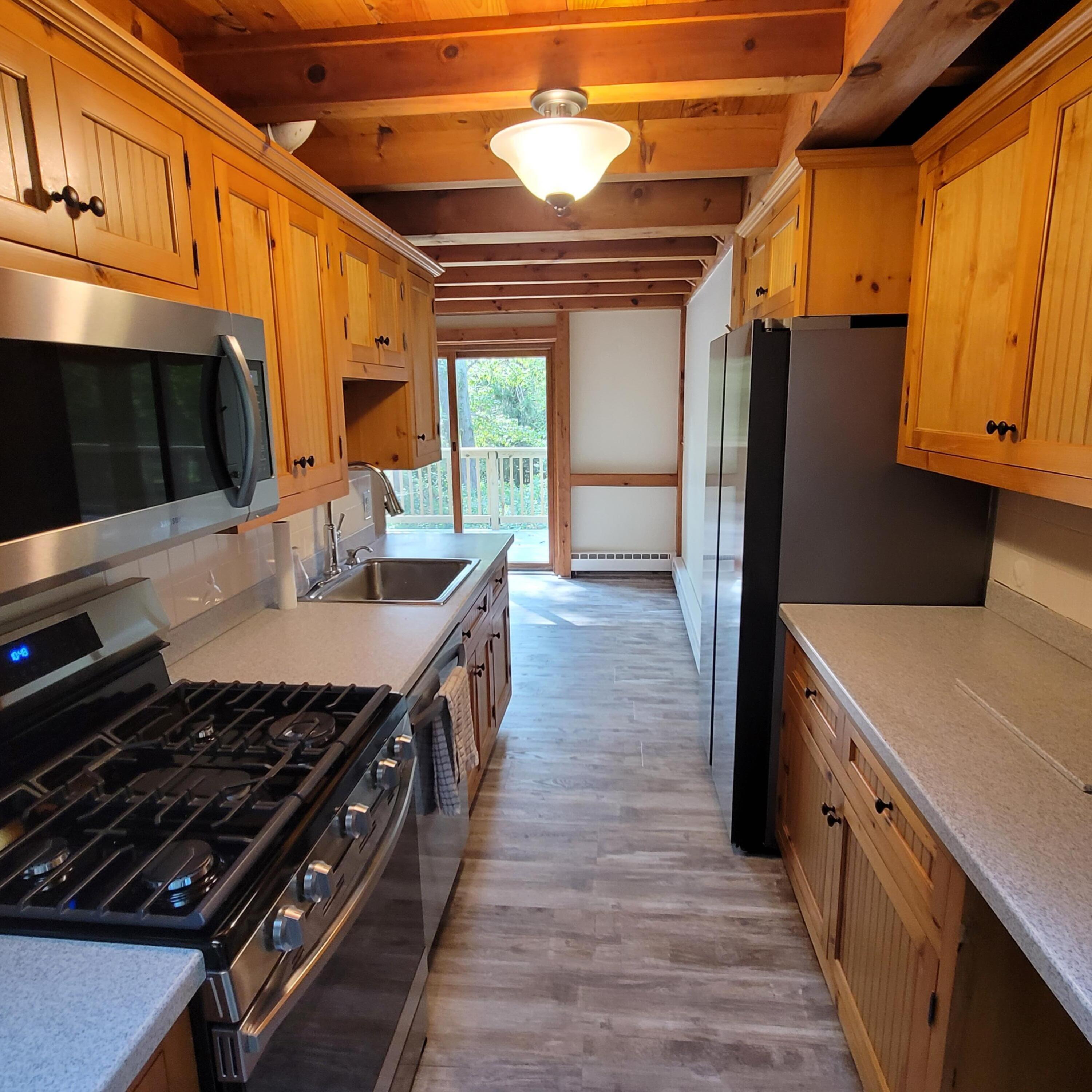 73 Suomi Road Hyannis, MA 02601 - Photo 5 of 13 a kitchen with stainless steel appliances a stove a refrigerator a sink and wooden cabinets