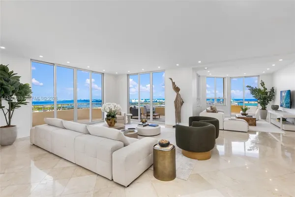 a living room with furniture kitchen view and a large window