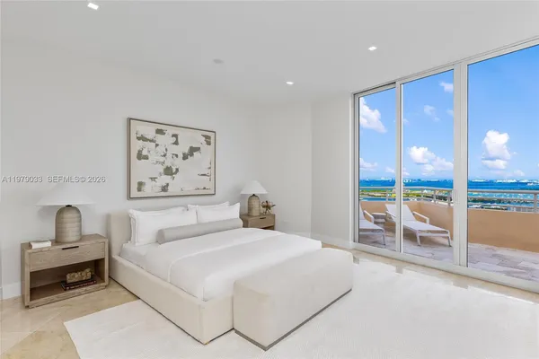 a bedroom with a large bed and a chandelier