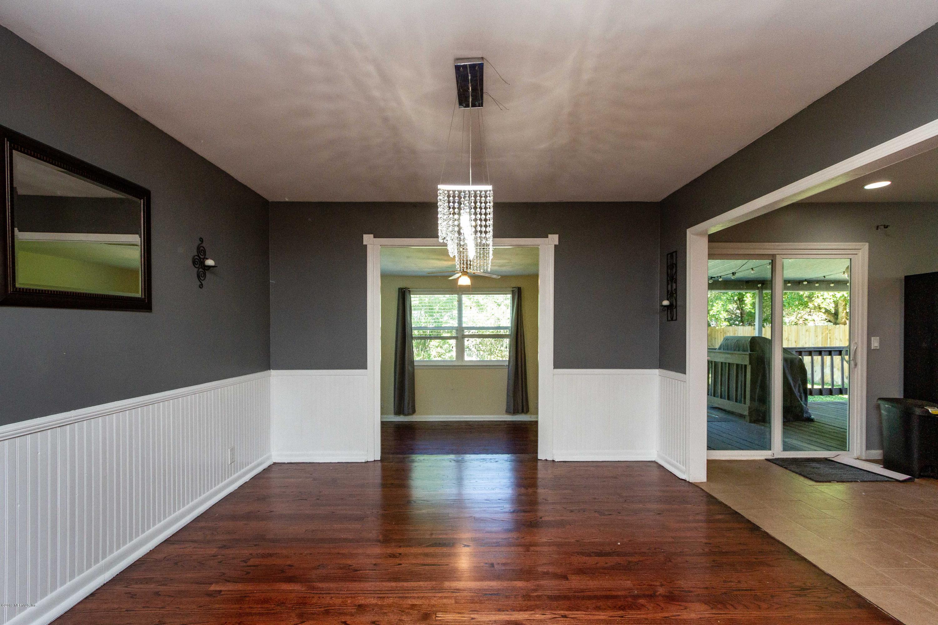 7420 Hennessy Road Jacksonville, FL 32244 - Photo 11 of 39 a view of an empty room with wooden floor and a window